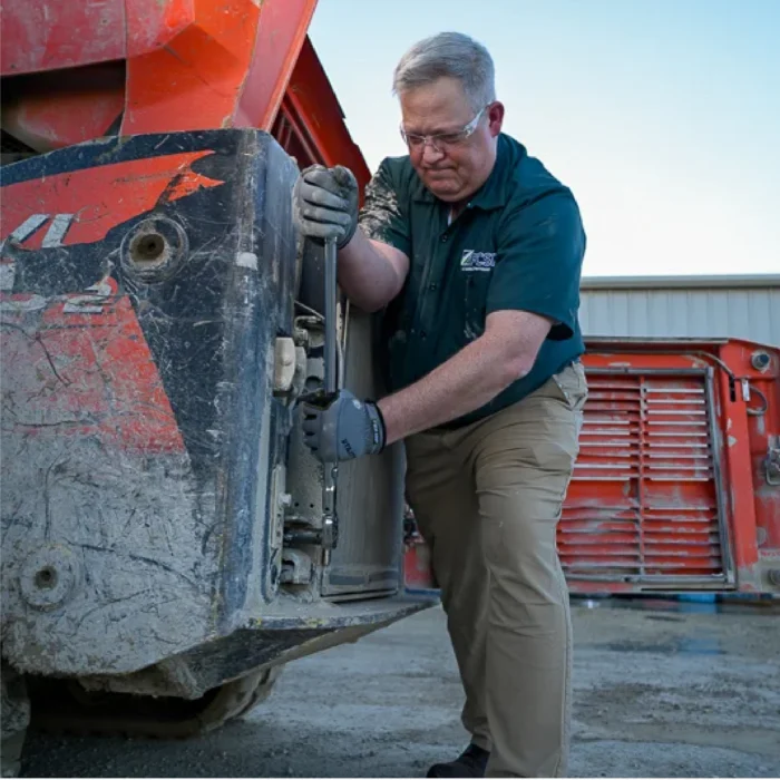 male working maintenance on construction equipment