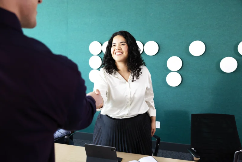 woman shaking hands with potential new hire in an office space