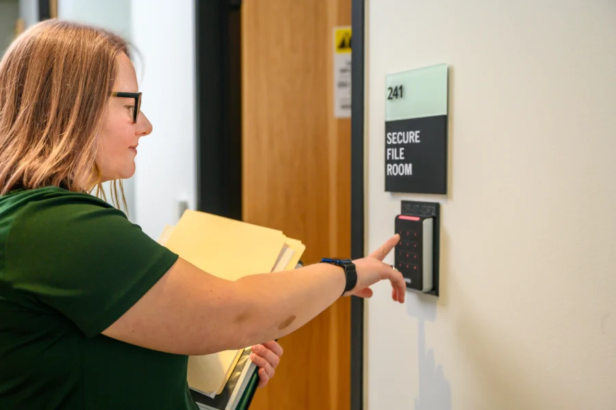 female is entering a code to a secure file room
