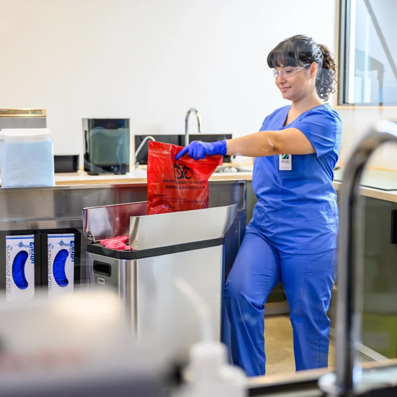 female is cleaning a hospital environment with a limb difference while wearing personal protection equipment
