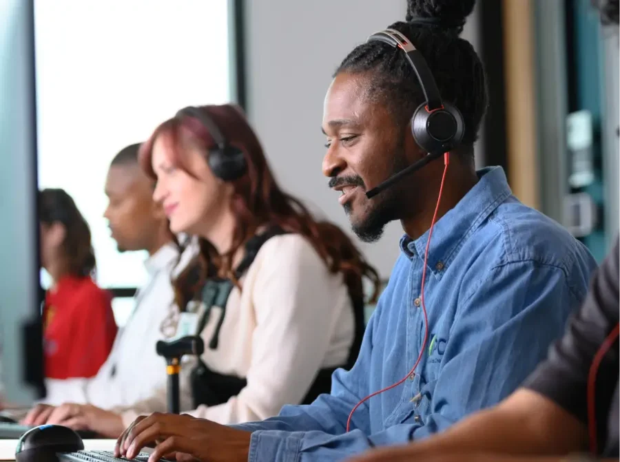 A call center team chatting on the phone with customers. They each wear headsets.